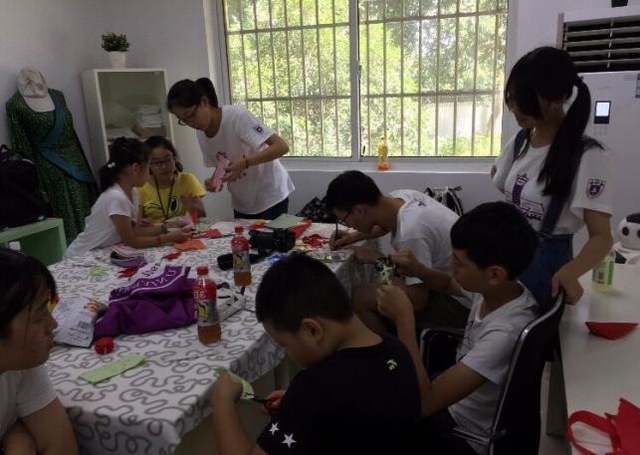 小组成员给孩子们教授剪纸技巧