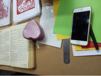 张老师正在读一本有关文化常识的书桌边放满了作画工具