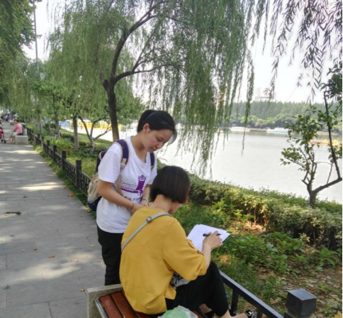 玄武湖公园团队成员在为阿姨解释问卷的内容