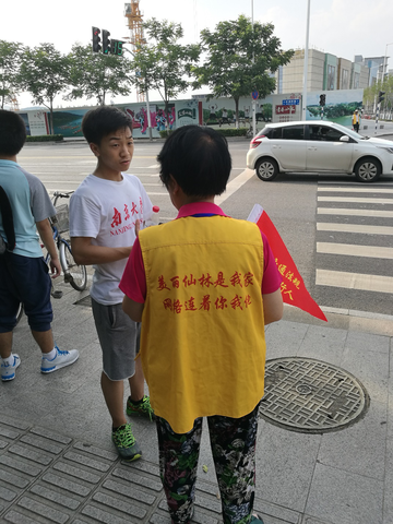 图为小队成员与管理交通的老奶奶交谈